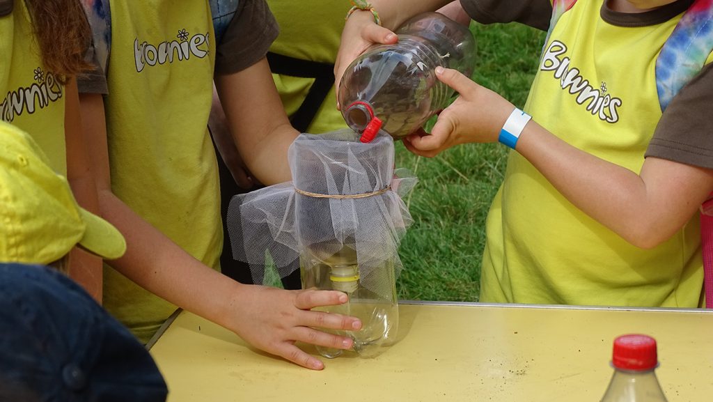 Brownies purifying water with nature filters, including charcoal, sand and gravel.  